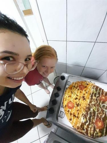 Alyssa and Sister Perri with an above angle shot of them and their pizza
