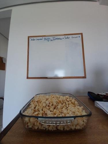 A pan of popcorn in front of Sister Grace's and Leopolde's whiteboard