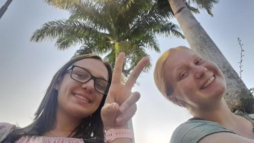 A selfie of Alyssa and Sister Leopoldes under a palm tree