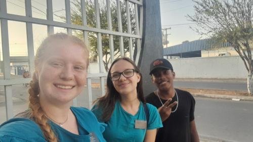 Alyssa and Sister Leopoldes outside with a guy showing a peace sign