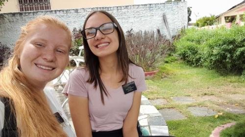 Alyssa and Sister Leopoldes outside selfie in front of a building and plants