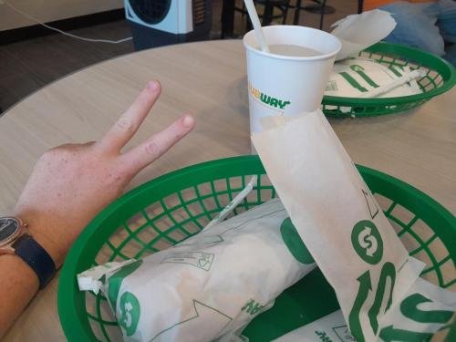Alyssa gives a peace sign at a Subway