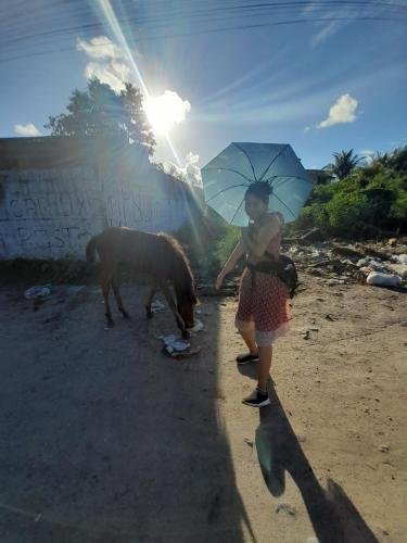 Sister Zurita with a little horse near a graffiti wall