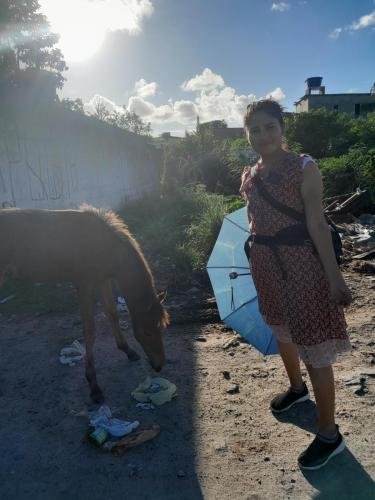 Sister Zurita with a little horse near a graffiti wall