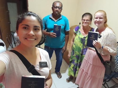 Alyssa and Sister Zurita with some members and Books of Mormon