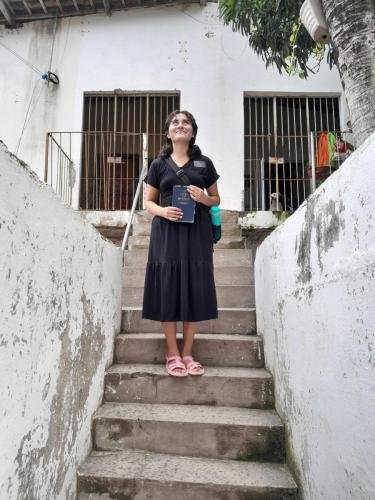 Sister Zurita on the stairs with a Book of Mormon