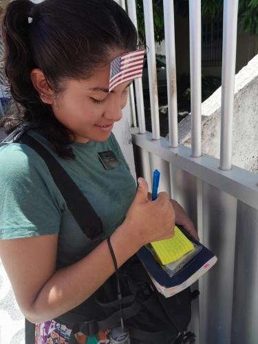 Sister Zurita with a US flag on her forehead while writing something