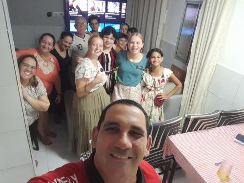 A selfie of Alyssa and Sister Tadje with a group of people watching a video