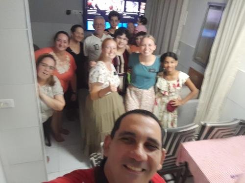 A selfie of Alyssa and Sister Tadje with a group of people watching a video