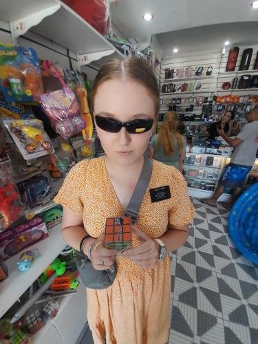 Sister Fisher in the toy store with sunglasses and a Rubik's Cube
