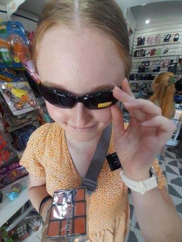 Sister Fisher in the toy store with sunglasses and a Rubik's Cube