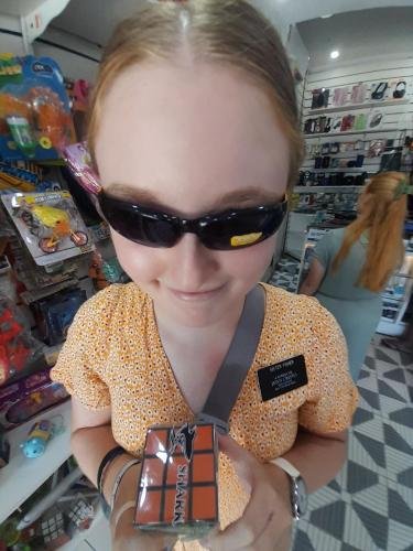 Sister Fisher in the toy store with sunglasses and a Rubik's Cube