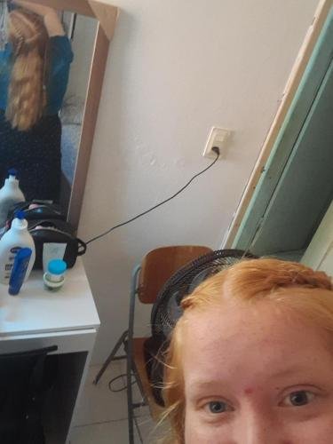 Alyssa showing her braids in the mirror