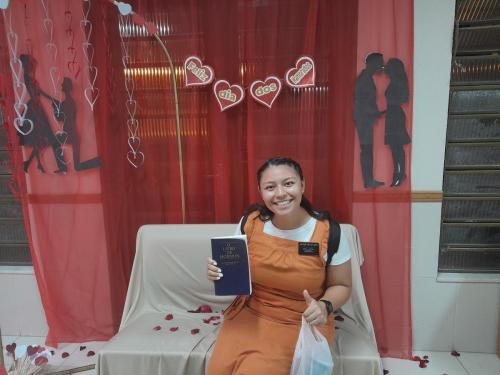 Sister Villatoro on the bench in front of the decorations about Day of Lovers