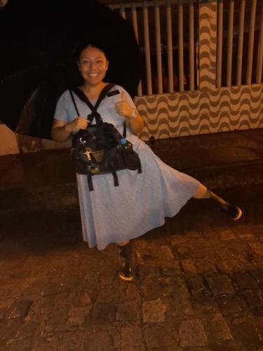 Sister Villatoro does a dance with her boots and umbrella in the street