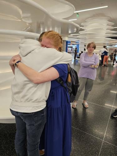 Alyssa hugs Elliot just before boarding her plane for her mission