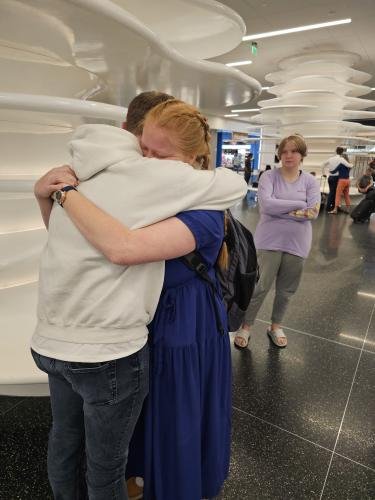 Alyssa hugs Elliot just before boarding her plane for her mission