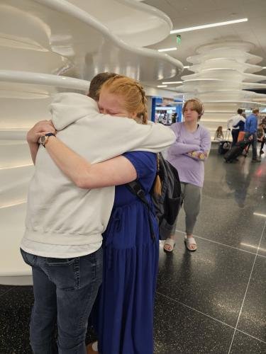 Alyssa hugs Elliot just before boarding her plane for her mission