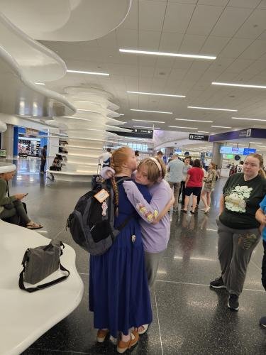 Alyssa gives Diana a hug before she boards her airplane for her mission