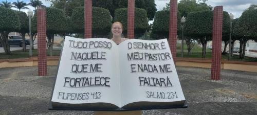 Alyssa in front of a big Bible in a park