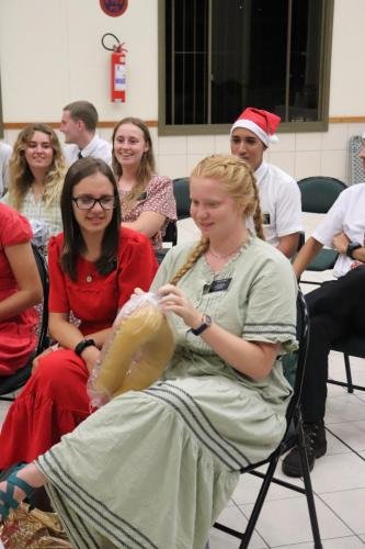 Alyssa gets a neck pillow during the 2023 mission Christmas party